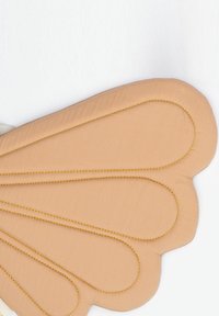 Őszibarackszínű párnázott kiegészítő pillangószárny formájában, varrásai sárga cérnával kiemelve, sima textúrával.