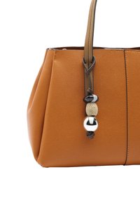 Brązowa torba tote ze strukturalną skórą o zwężającym się kształcie, z dekoracyjnym paskiem ozdobionym trzema koralikami w kolorze czarnym, kremowym i srebrnym.