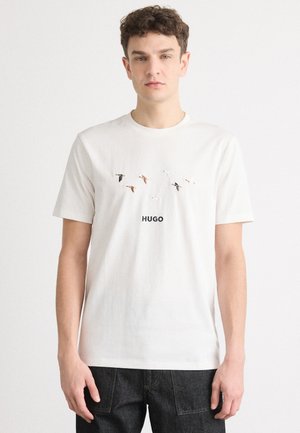 White cotton T-shirt featuring a graphic of flying birds and the word "HUGO" in black. Classic crew neckline and short sleeves.