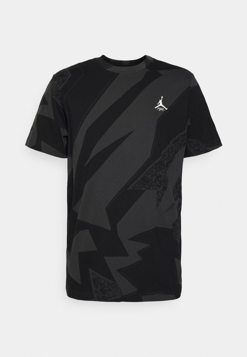Camiseta de manga corta negra y gris oscuro con un patrón abstracto, con pequeño logo blanco de Jumpman en el lado izquierdo del pecho.