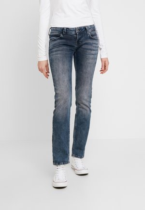 Jean droit bleu en denim avec un lavage délavé. Dispose d'un design à cinq poches et de coutures d'accent légères. Portés avec des baskets blanches.