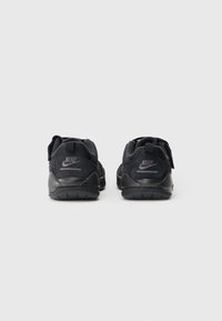 Črne Nike superge z zgornjim delom iz semiša in mrežastega materiala, okroglo obliko, vezalkami in logotipom na peti. Gumijast podplat za dober oprijem.