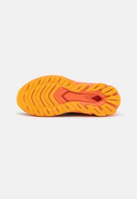 Suola delle scarpe da corsa in tonalità di arancione e giallo. Gomma testurizzata con scanalature profonde per una buona aderenza. Design curvo per una maggiore flessibilità.