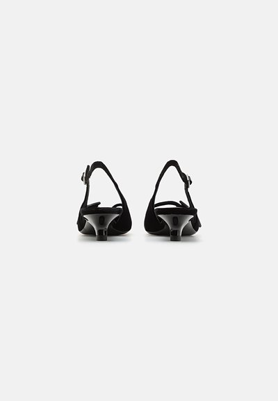 Black suede slingback heels with a low glossy heel, featuring a buckle strap and soft texture. Minimalist design with elegant silhouette.