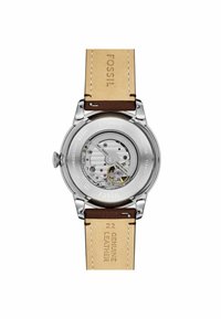 Orologio automatico con fondello trasparente, cassa in acciaio inox argentato, cinturino in pelle marrone e dettagli del movimento visibili.