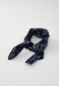 Foulard bandana blu navy in tessuto leggero, con un motivo paisley bianco, annodato e con due estremità pendenti.