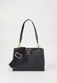 Tumesinist nahast käekott struktureeritud kujuga, kuldsete detailide, lühikese ülaosas oleva sangaga ja eemaldatava nailonrihmaga. Omab silmapaistvat logoelementi.