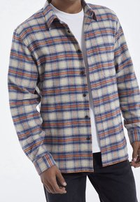 Flanellen overhemd met een geruit patroon in blauw, oranje en roomkleur. Het heeft een knoopsluiting aan de voorkant en een verspreide kraag, met lange mouwen.