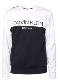 Felpa in bianco e nero con scollatura rotonda. "CALVIN KLEIN" e "NEW YORK" stampati in lettere grasse sul petto. Polsini e orlo a costine.