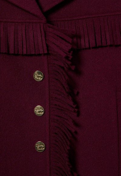 Chaqueta burdeos con un detalle de flecos en el cuello, tres botones dorados y una textura de lana suave.