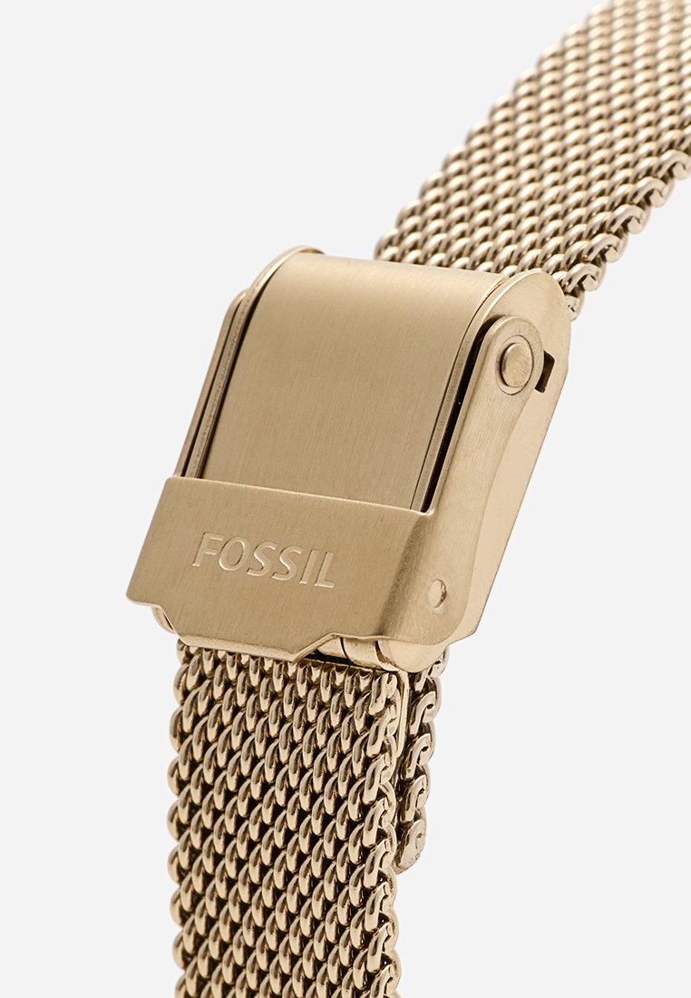 Bracciale in maglia dorata con chiusura metallica che presenta il logo "FOSSIL". Il design texturizzato offre un aspetto raffinato e durevole.