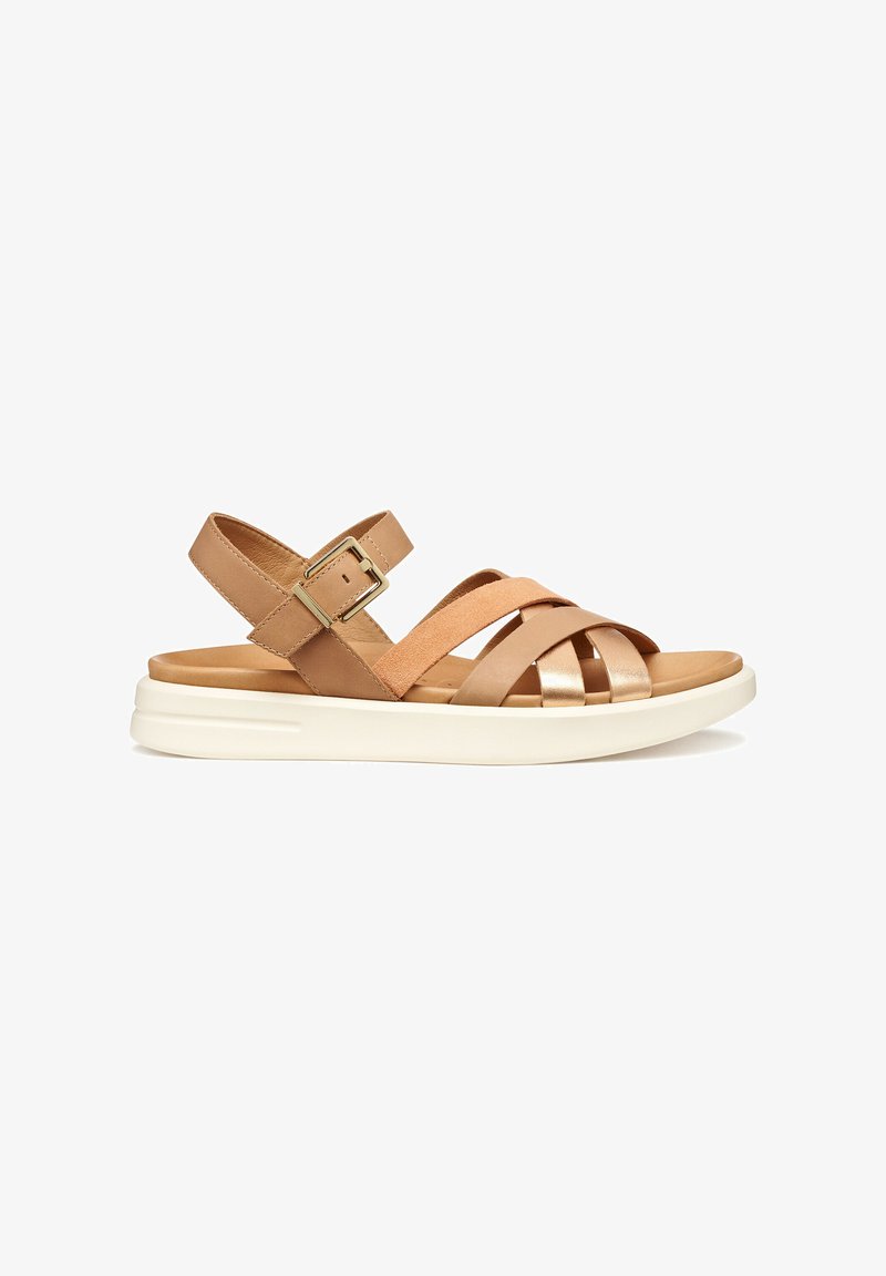Tan leather and suede sandal with crossed straps, adjustable buckle, and a white platform sole designed for comfort and stability.