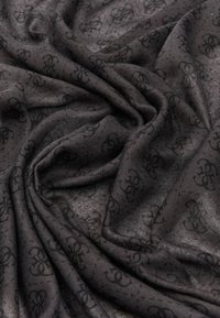 Écharpe noire avec une texture finie, présentant un motif sombre répétitif. Le tissu semble doux et légèrement transparent, avec des drapés fluides.