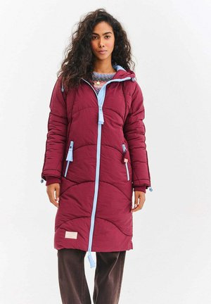 Bordowy ocieplany płaszcz z niebieskim zamkiem błyskawicznym i sznurkami, o pikowanej strukturze, z bocznymi kieszeniami i długości do kolan.