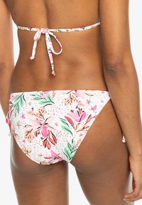 Bikini med blommönster i rosa, gröna och persikofärgade nyanser. Utmärkande drag inkluderar en knytning i ryggen och en lågt skuren nederdel med justerbara sidor.