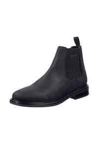Černé kožené Chelsea boty s hladkým povrchem, elastickými bočními panely a nízkým nakupeným podpatkem. Disponují poutkem pro snadné obouvání.