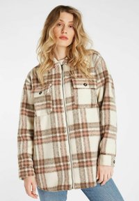 Gekblokte plaid jas van zacht materiaal in de kleuren crème, bruin en roze, met ritssluiting en twee borstzakken.