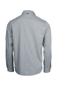 Chemise gris clair à manches longues vue de dos avec des poignets boutonnés et une petite étiquette sous le col.