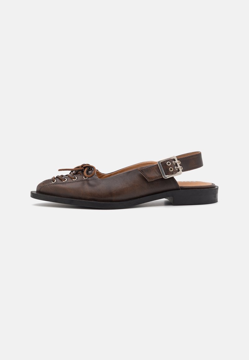 Brown leather slingback shoe with rounded toe, lace-up front, and a buckle closure on the strap. Flat sole with minimal tread.