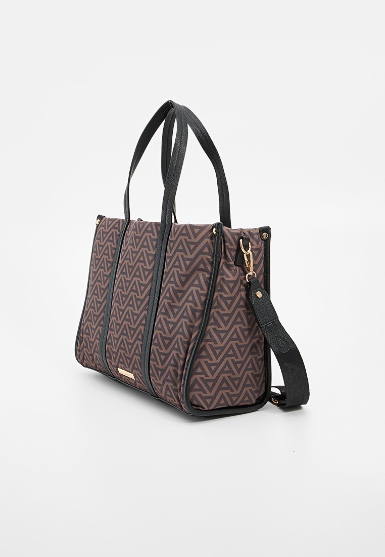 Sac fourre-tout à motif marron avec des accents en cuir noir. Comprend deux anses et une bandoulière amovible. Design géométrique sur le tissu.