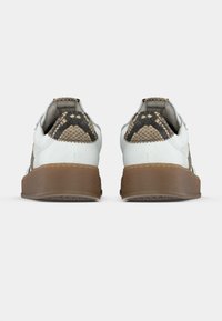 Άσπρα αθλητικά παπούτσια με υφή καφέ καουτσούκ σόλας. Η πίσω πλευρά διαθέτει διακοσμητικό με σχέδιο φολιδωτού δέρματος και επενδυμένο γιακά για άνεση.