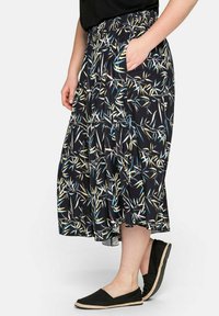 Černá sukně s květinovým vzorem, elastickým pasem a bočními kapsami. Design obsahuje bílé, žluté a modré prvky listů.
