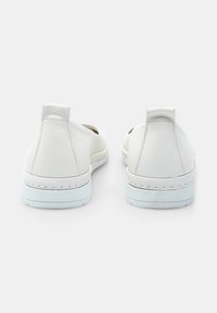 Scarpe slip-on bianche in pelle con forma arrotondata, design a profilo basso e suole in gomma bianche a contrasto. Dotate di linguette posteriori per una facile calzata.