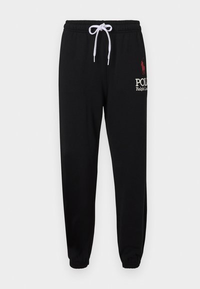 Čierne tepláky s elastickým pásom a bielou šnúrkou. Obsahujú červené logo polo a nápis "Polo Ralph Lauren" v bielej farbe. S manžetami na členkoch.