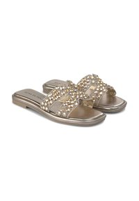 Metalen gouden slide-sandalen hebben decoratieve rhinestones, een open te ontwerp en een platte zool voor gemakkelijk aan- en uittrekken. Glad textuur met glanzende accenten.