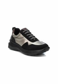 Zapatilla negra y plateada metálica con una parte superior texturizada, detalles de cordones y una suela gruesa. Presenta un acabado suave y materiales en contraste.