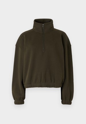 Oliven grønn cropped hettegenser laget av myk stoff, med høy krage, halv-lukking med glidelås, og elastiske mansjetter og kant.