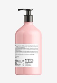 Roze plastic fles met een zwarte pompdeksel, met een ronde body en een platte onderkant. Gedetailleerd etiket aan de achterkant met productinformatie en symbolen.