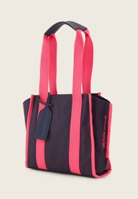 Borsa tote in denim navy con manici fucsia brillanti, dalla forma rettangolare, con texture intrecciata e una piccola etichetta attaccata con il marchio.