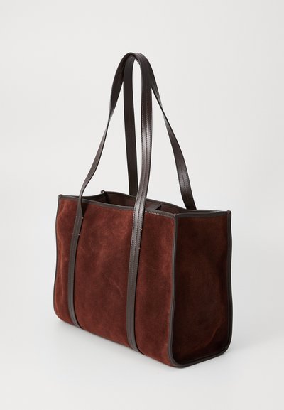 Sac fourre-tout en daim marron avec des poignées et des garnitures en cuir marron foncé, présentant une forme rectangulaire et un design à décaissement.