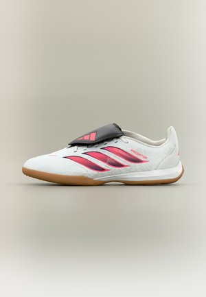 Hvid og pink Adidas Predator indendørs fodboldstøvle med gummisål og sort snørebåndsdække, vist fra siden på en neutral baggrund.