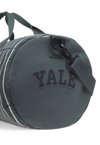 Zelena cilindrična torba iz trpežne tkanine, s črnimi črtami in napisom "YALE" v bold črnih črkah. Vključuje črn sponko in trak.
