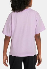 Camiseta de algodón lila de manga corta, con un corte suelto y un escote redondeado. Presenta un diseño liso sin gráficos ni acentos visibles.