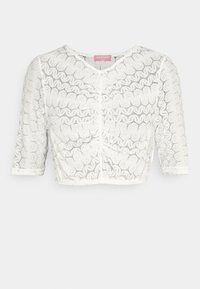 Top court blanc en dentelle avec des motifs en ondulations, dotée d'un col rond et de manches trois-quarts. Étiquette visible à l'intérieur du col.