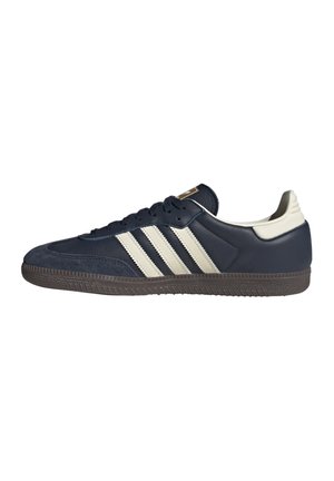 Lavprofil sort sneaker med hvid hælfane og tre hvide sidelister, sorte snørebånd og tekstureret mørk sål.