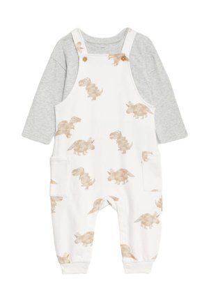 Hvide overalls med beige dinosaurtryk, med en grå langærmet skjorte under. Lavet af blødt bomuld, inkluderer sidelommer og knapper.