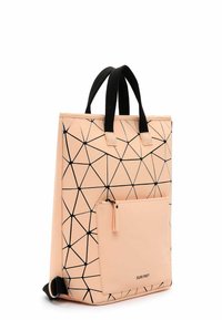 Torba tote w kolorze brzoskwiniowym z czarnym geometrycznym wzorem, posiadająca dwa czarne uchwyty, przednią kieszeń na zamek błyskawiczny oraz wyrazisty kształt.