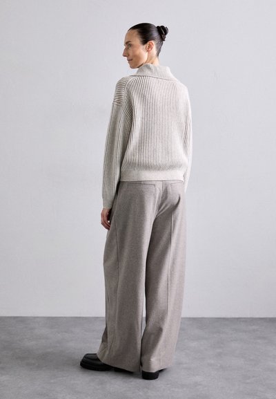 Light gray ribbed knit sweater with a collar, paired with wide-leg gray trousers. Black chunky footwear completes the look.