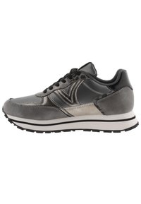 Zapato deportivo gris que presenta una combinación de materiales lisos y texturizados, una forma redondeada, cordones negros y una suela media blanca con acentos negros.