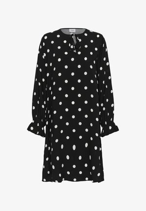 Zwarte jurk met lange mouwen en witte stippen, met gerimpelde manchetten en een klein strikje bij de ronde hals.