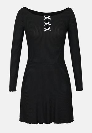 Crna rebrasta haljina s dugim rukavima i izrezom s ramena. Ima tri bijela vezana detalja sprijeda i lepršavi rub.