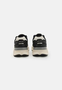 Baskets noires et crème avec tige en mesh, semelle amortissante et accent transparent. Logo "REPLAY" sur le talon.
