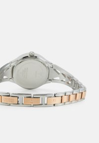 Orologio in acciaio inossidabile con bracciale in argento e oro rosa. Caratterizzato da una cassa rotonda minimalista e loghi incisi sui link metallici.