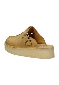 Scarpa slip-on in suede tan con punta arrotondata, dettaglio in pelle con fibbia e suola in gomma leggera di colore naturale.