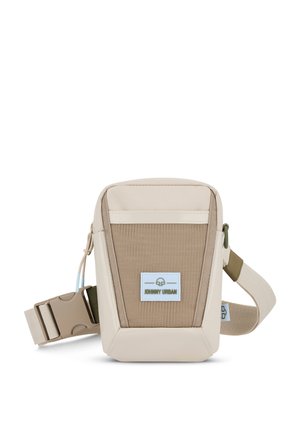 Beige and tan crossbody bag with textured fabric, adjustable strap, front logo patch, and smooth accents. Compact and angular design.