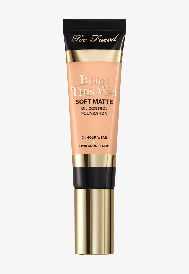 Fond de teint mat doux Born This Way de Too Faced dans un tube beige avec des accents noirs et dorés, conçu pour contrôler l'huile, avec un applicateur à pompe.
